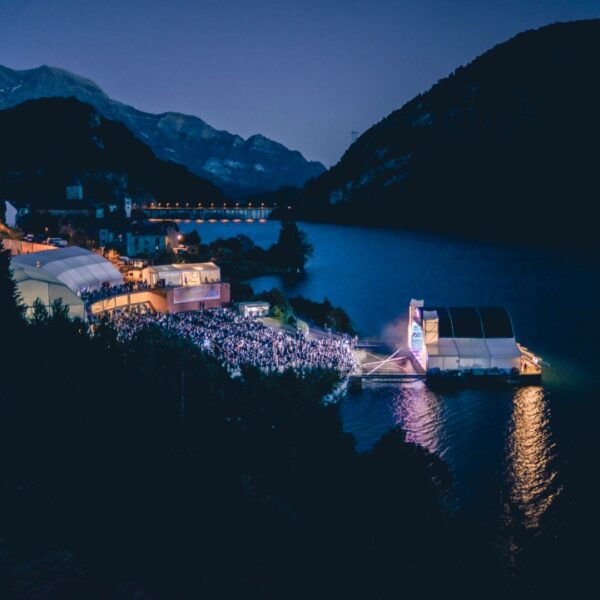Vista aérea nocturna del Auditorio de Lanuza lleno de público junto al pantano.