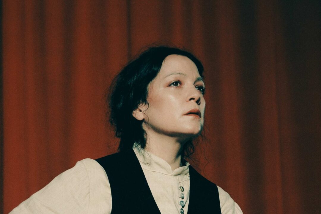 Natalia Forcade con un telón rojo al fondo